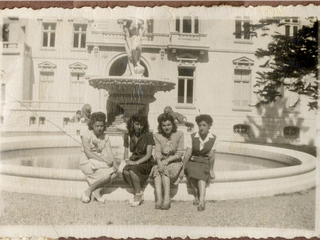 Cuatro niñas sentadas en el frontis del Palacio Cousiño. Víctor M. Alegría G. 1940. Fondo General. Biblioteca Nacional