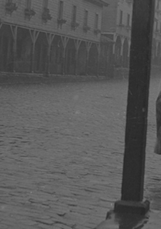 Señoras caminando en un día de lluvia por una calle de Lota. Ignacio Hochhäusler, 1950. Biblioteca Nacional de Chile.